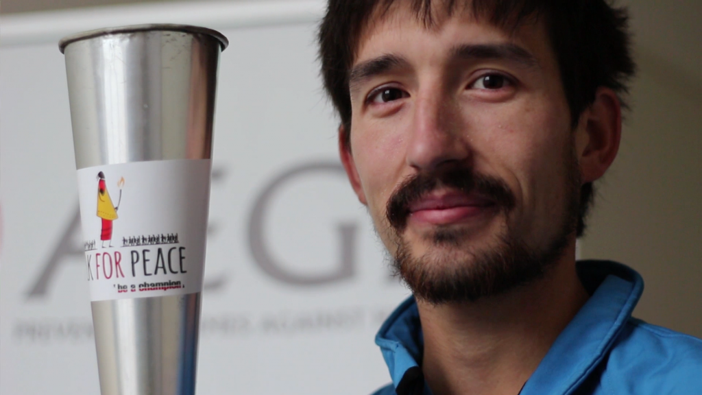 World record-breaking endurance runner Adam Holland holds the 'Torch for Humanity'.